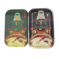 Two metallic rectangular anime 3d magnetic rolling trays with colorful meditative character artwork atop creatures