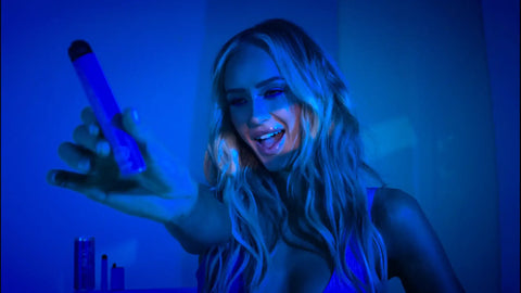 Blue cylindrical vape pen held in hand