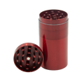 Red metallic cylindrical herb grinder with diamond-shaped teeth and central hole from stealth storage grinder