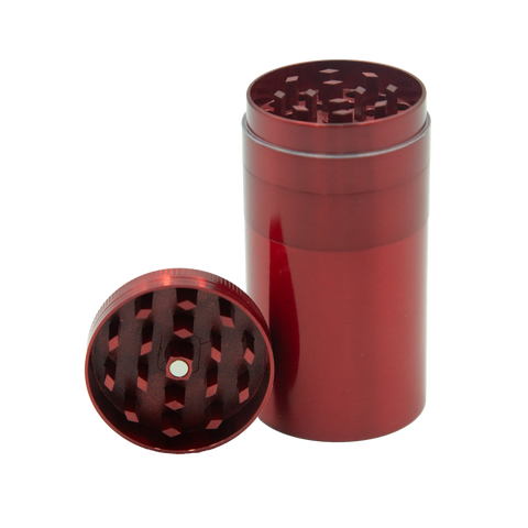 Red metallic cylindrical herb grinder with diamond-shaped teeth and central hole from stealth storage grinder