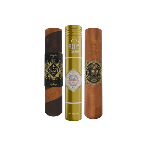 Three premium cigars displayed in their branded packaging: a dark brown ’grand signet’ cigar, a gold-tube ’libertad imperial reserve,’ and an unboxed natural tobacco-colored cigar.