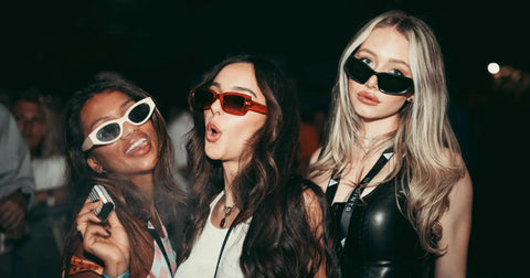 Three women wearing stylish sunglasses, white, red, and black frames, with bold, modern designs.